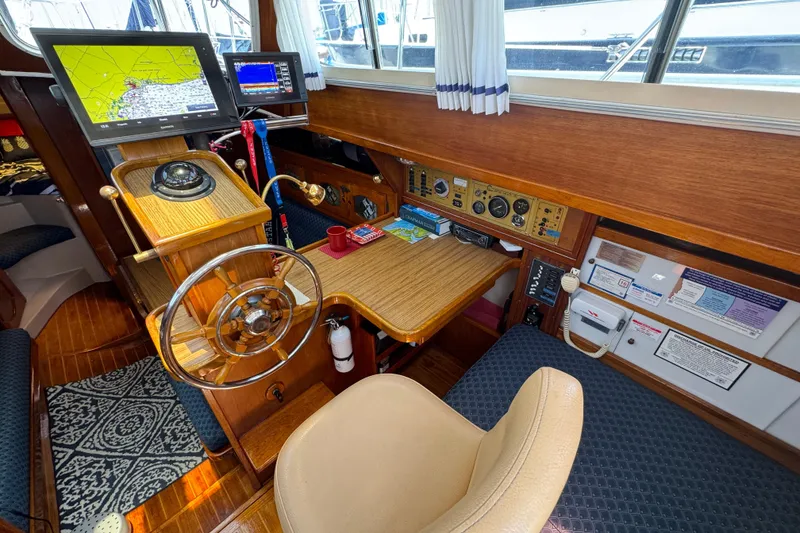 1989 Gulf Pilot House interior with navigation equipment and wooden steering wheel.