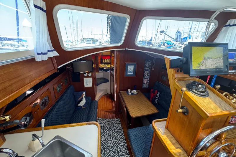 1989 Gulf Pilot House interior with nautical decor, featuring navigation equipment and cozy seating.