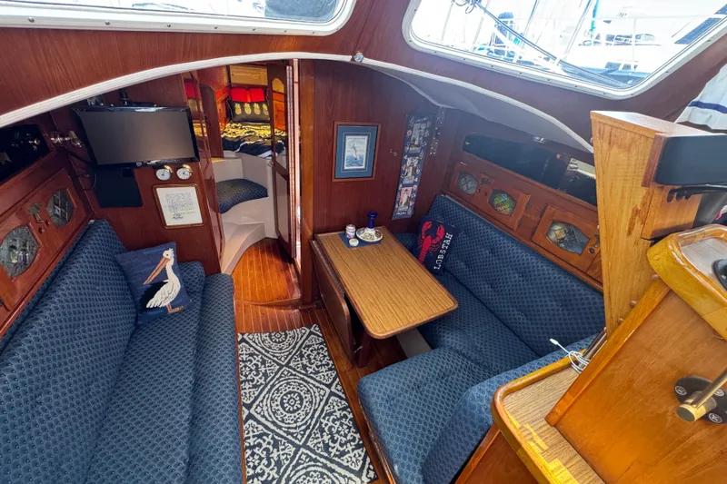 Cozy 1989 Gulf Pilot House interior with blue seating, wooden accents, and nautical decor.