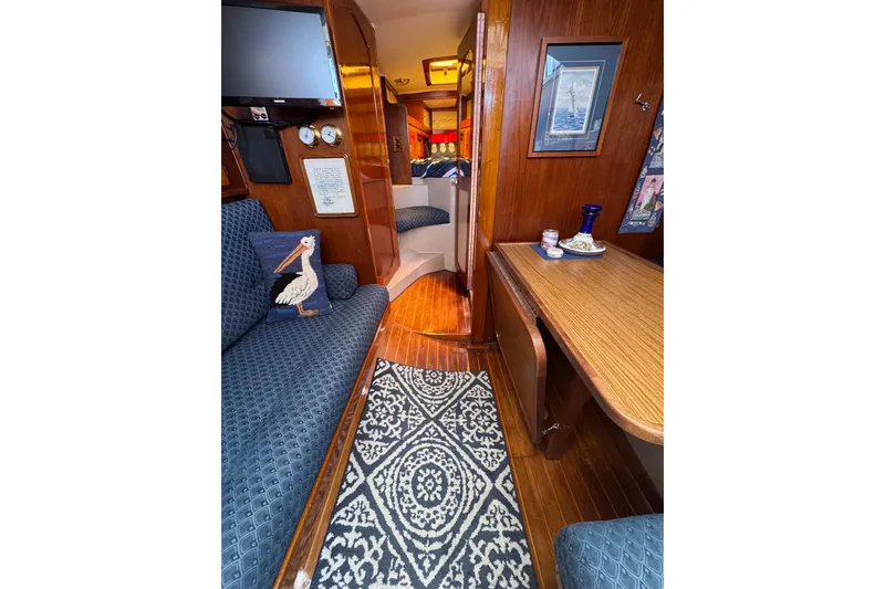 Interior of 1989 Gulf Pilot House boat with cozy seating and nautical decor.