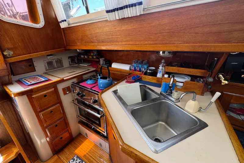 1989 Gulf Pilot House kitchen with wooden cabinetry, stove, and dual sink.