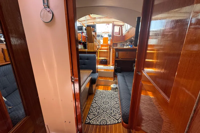 Interior of 1989 Gulf Pilot House boat with wooden finishes and seating area.