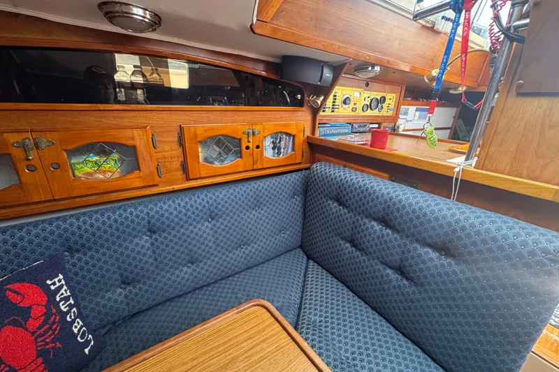 Cozy interior of a 1989 Gulf Pilot House boat with wooden cabinets and blue upholstery.