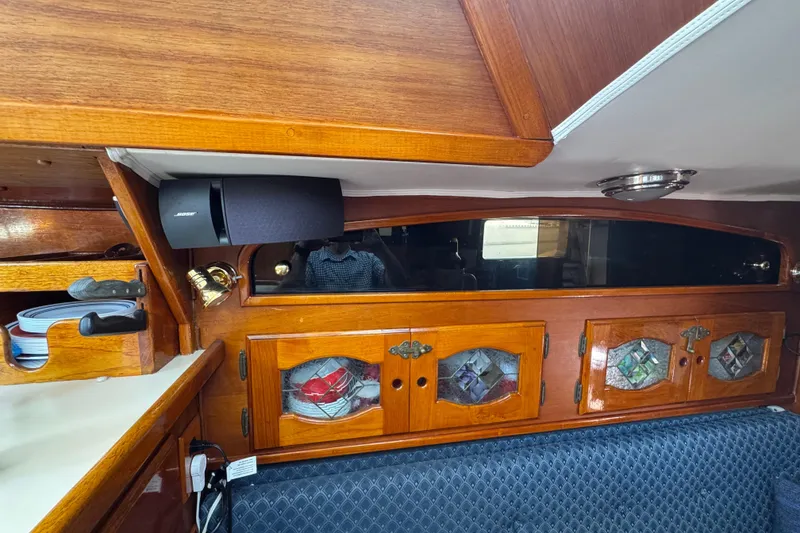 1989 Gulf Pilot House interior with wooden cabinets, stained glass, and Bose speaker.