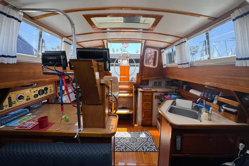 Interior of a 1989 Gulf Pilot House boat with wooden finishes and nautical equipment.