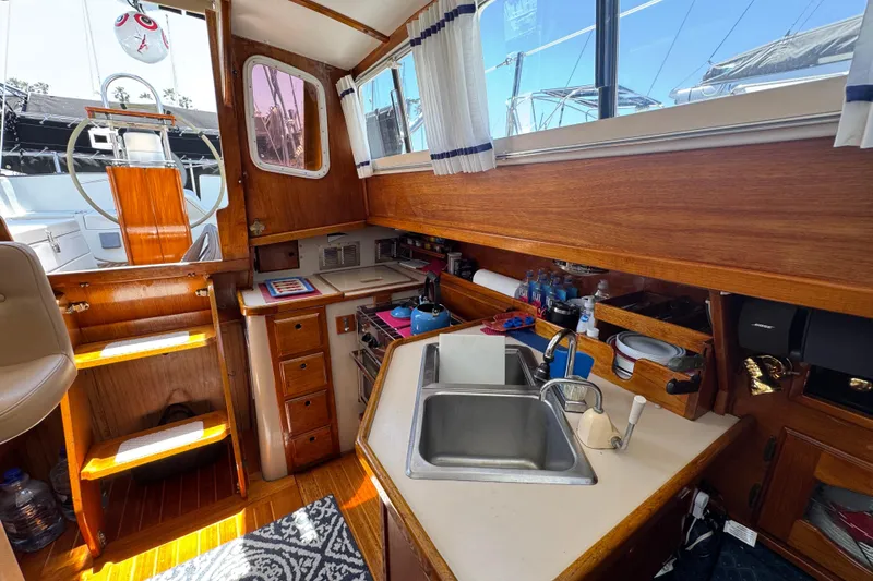 1989 Gulf Pilot House interior with wooden cabinetry, sink, and nautical decor.