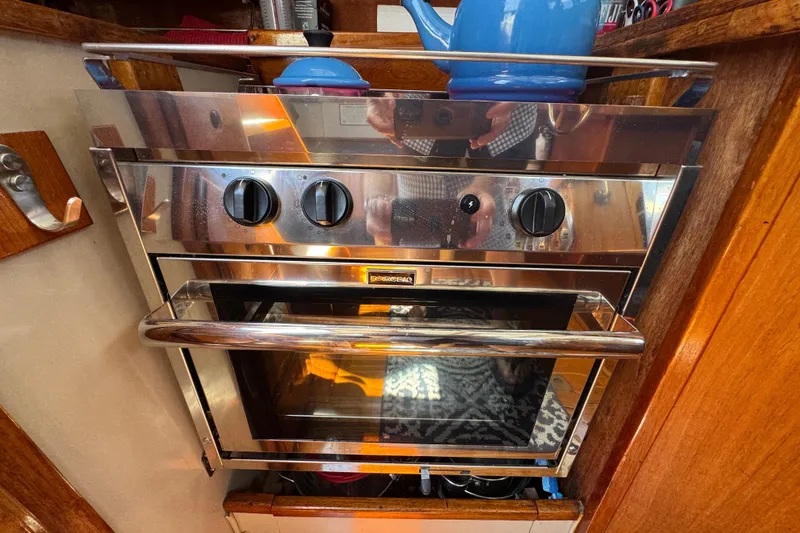 Stainless steel oven in 1989 Gulf Pilot House kitchen with blue kettle on top.