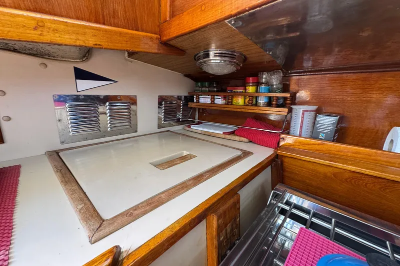 1989 Gulf Pilot House kitchen with wooden cabinetry, spice rack, and stainless steel accents.