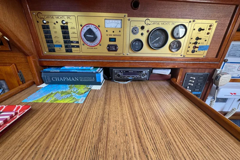 Control panel of a 1989 Gulf Pilot House boat with navigation books and equipment.