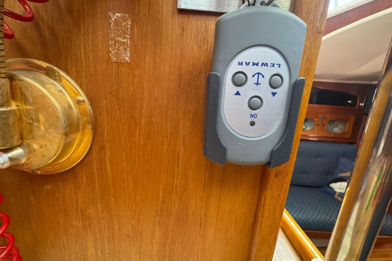 Remote control on wooden panel inside 1989 Gulf Pilot House boat cabin.