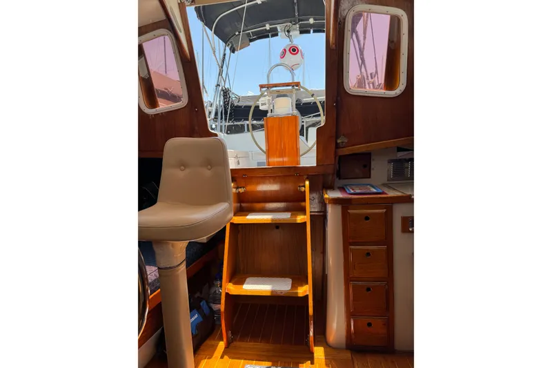 Interior view of 1989 Gulf Pilot House boat, featuring wooden steps and seating.