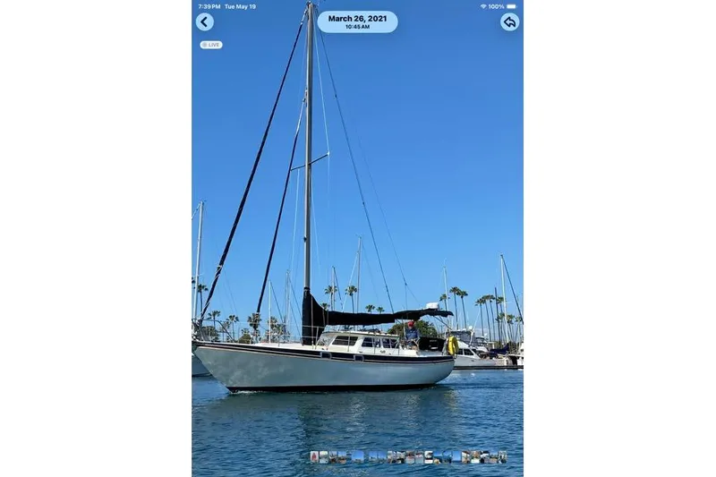 Sailboat in marina, 1989 Gulf Pilot House, clear blue sky, palm trees in background.