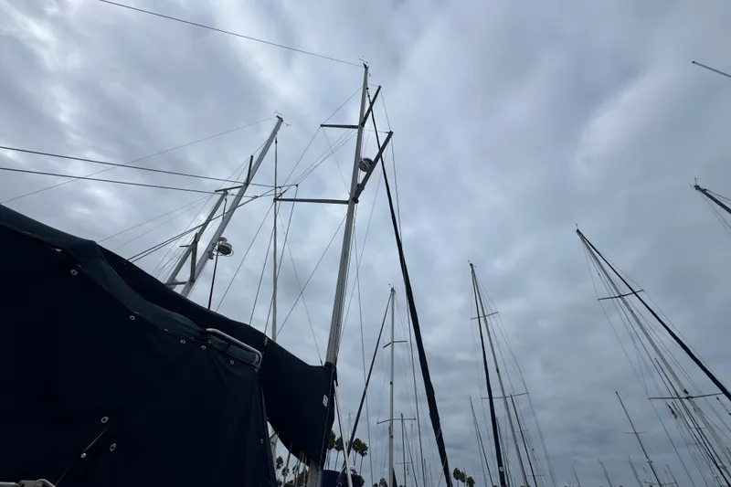 Sailboat masts against cloudy sky, featuring 1999 Hunter Passage 420.