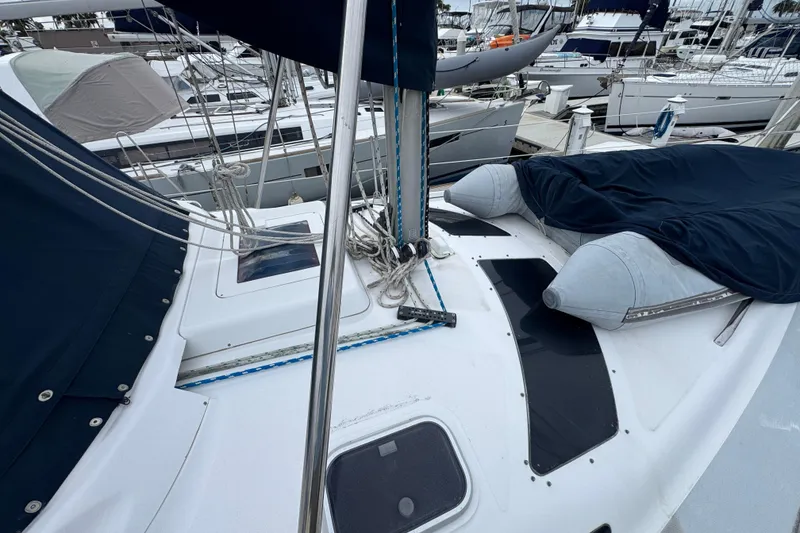 1999 Hunter Passage 420 sailboat deck with ropes and covered equipment in marina.