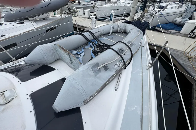 1999 Hunter Passage 420 sailboat with inflatable dinghy on deck at marina.