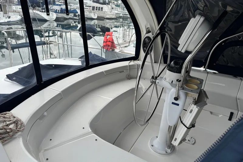 Cockpit of 1999 Hunter Passage 420 sailboat with steering wheel and marina view.