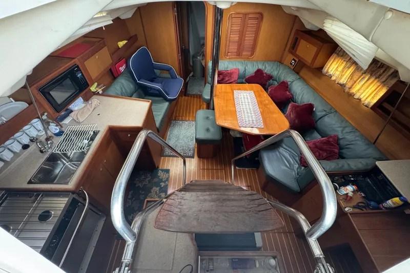 Interior of 1999 Hunter Passage 420 yacht with cozy seating and kitchen area.