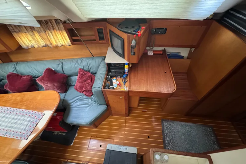 Interior of 1999 Hunter Passage 420 yacht with cozy seating and wooden furnishings.