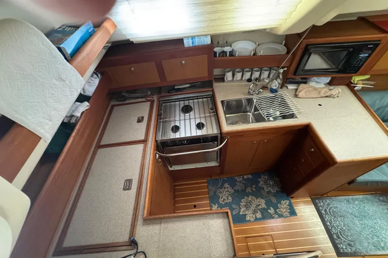 1999 Hunter Passage 420 yacht kitchen with stove, sink, and microwave.
