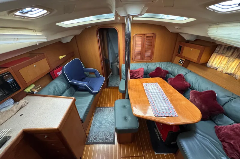 Interior of 1999 Hunter Passage 420 yacht with cozy seating and wooden finishes.