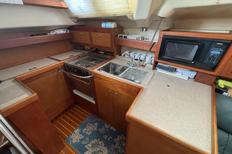 1999 Hunter Passage 420 yacht kitchen with stove, sink, and microwave.