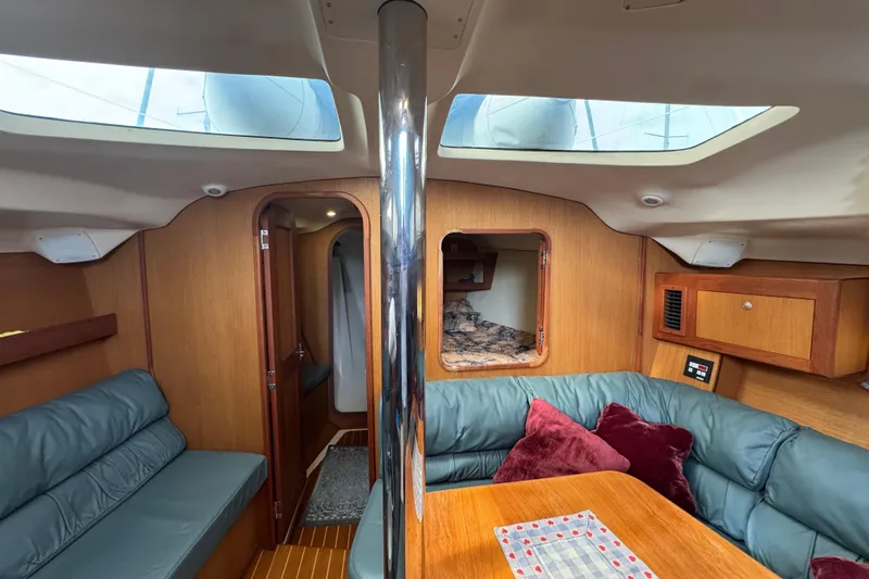 Cozy interior of 1999 Hunter Passage 420 sailboat with skylights and seating area.