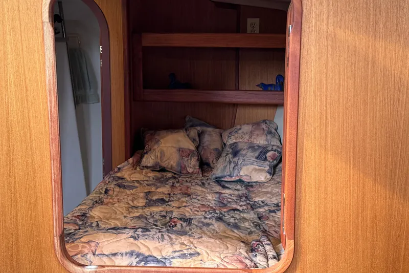 Cozy cabin interior of 1999 Hunter Passage 420 sailboat with patterned bedding.