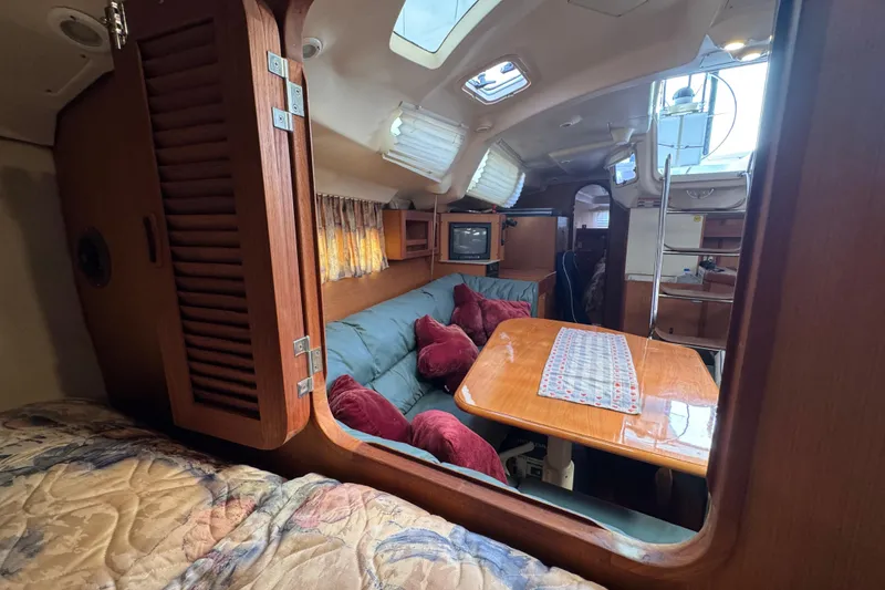 Cozy interior of 1999 Hunter Passage 420 sailboat with wood finishes and seating area.
