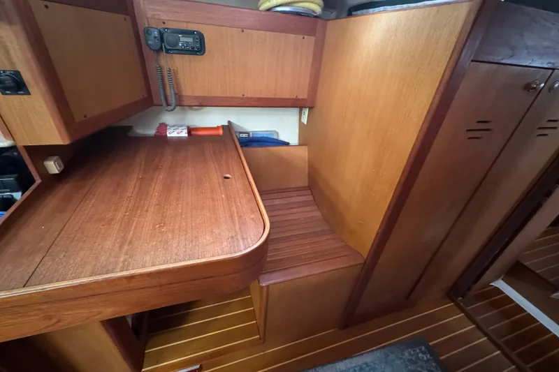 Interior of 1999 Hunter Passage 420 sailboat with wooden cabinetry and navigation station.