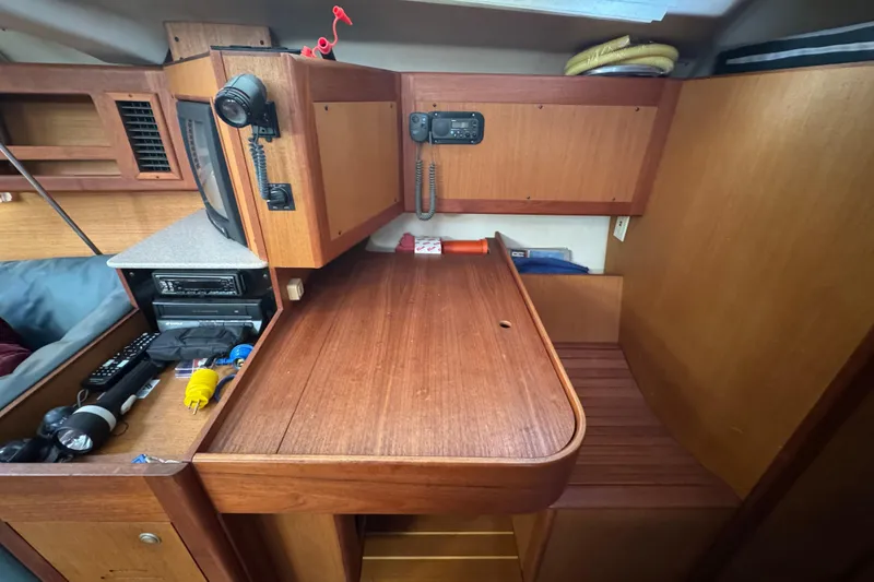 Interior of 1999 Hunter Passage 420 sailboat with wooden cabinetry and navigation equipment.