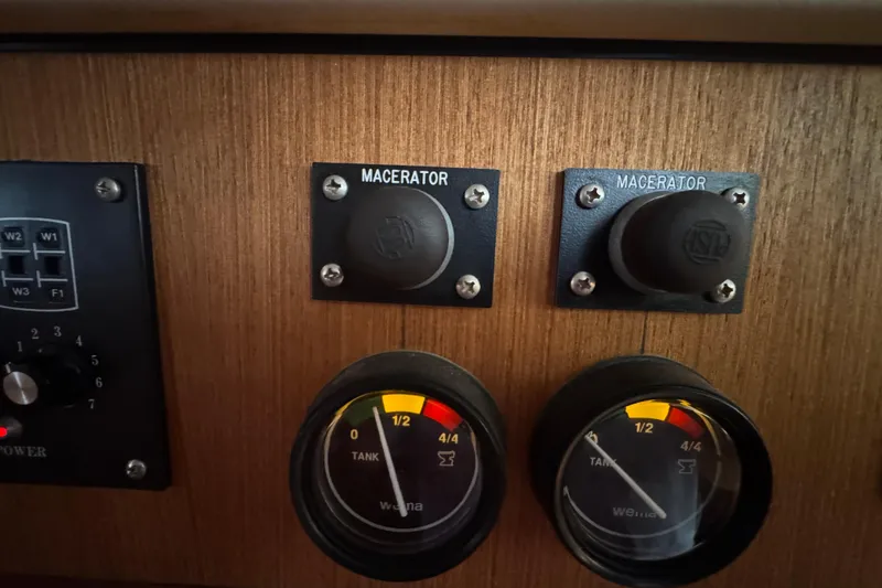 Control panel of a 1999 Hunter Passage 420 yacht with macerator switches and tank gauges.