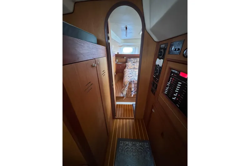 Interior view of 1999 Hunter Passage 420 sailboat, featuring wood paneling and cozy cabin.