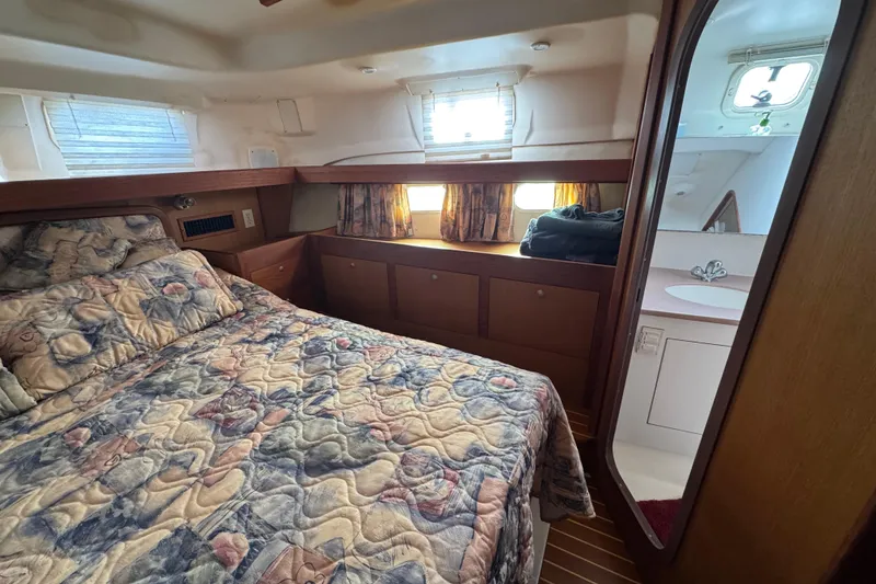 Cozy cabin interior of 1999 Hunter Passage 420 yacht with bed and ensuite bathroom.