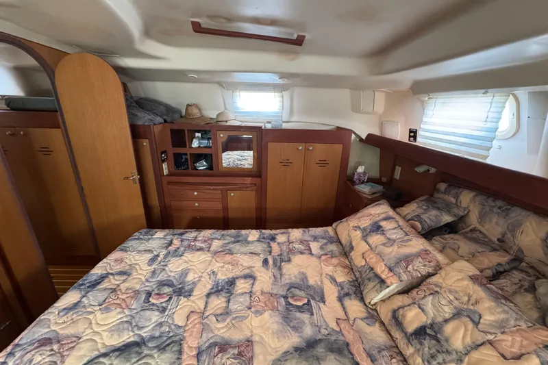 Cozy cabin interior of 1999 Hunter Passage 420 yacht with bed and wooden storage.