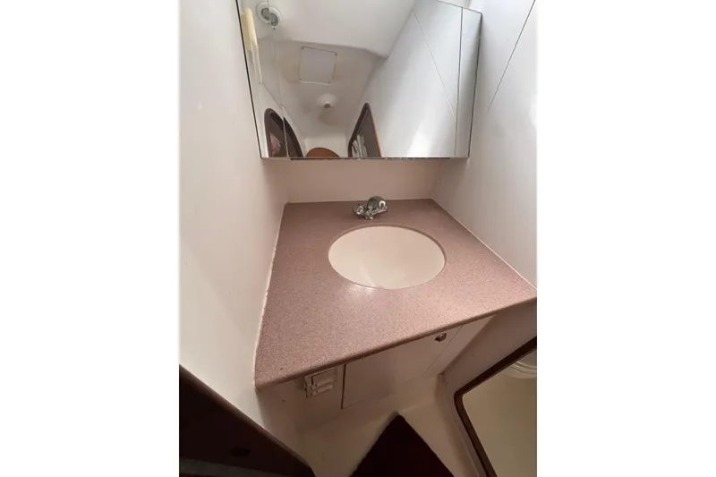 Bathroom vanity in 1999 Hunter Passage 420 yacht with mirror and sink.