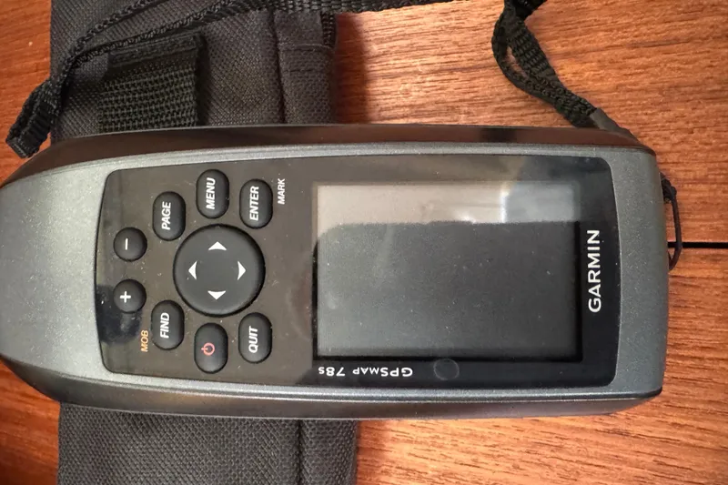 Handheld Garmin GPSMAP 76S device on wooden surface, associated with 1999 Hunter Passage 420.