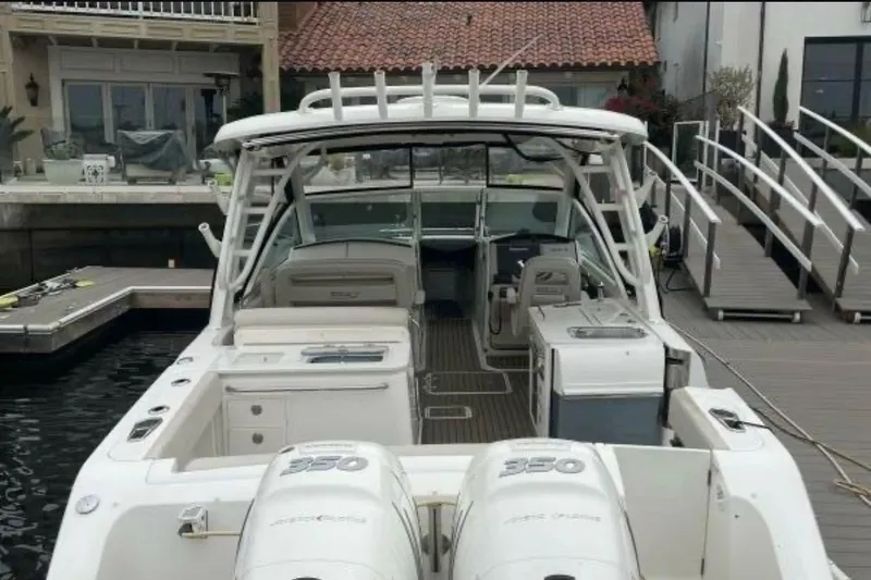 2018 Boston Whaler 320 Vantage boat docked, featuring dual engines and spacious seating.