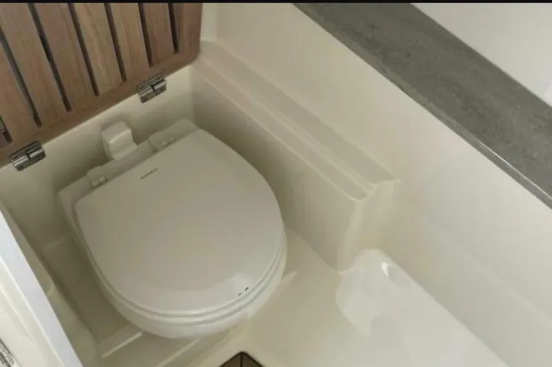 2018 Boston Whaler 320 Vantage boat toilet with wooden accents and modern design.