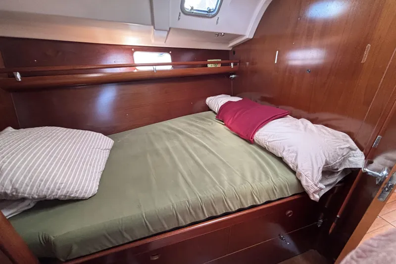 Cozy cabin interior of 1997 Beneteau Oceanis 400 sailboat with wooden finish and bedding.
