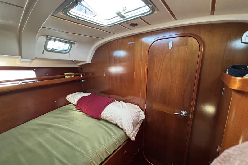 Cozy cabin interior of 1997 Beneteau Oceanis 400 sailboat with wooden finish and bedding.