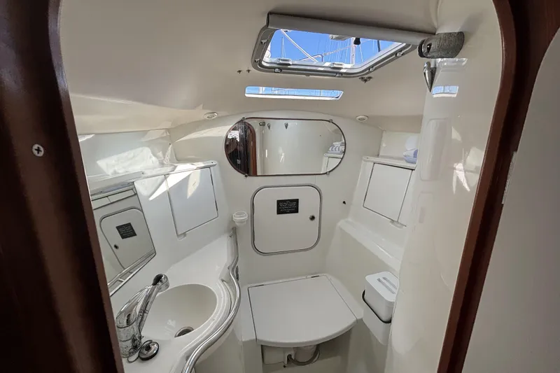 Interior of 1997 Beneteau Oceanis 400 yacht bathroom with sink, mirror, and storage.