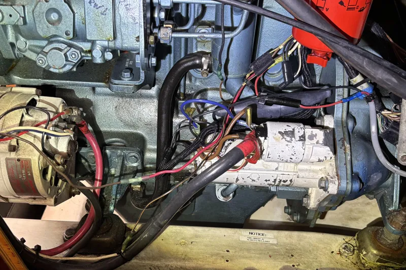 Engine components of a 1997 Beneteau Oceanis 400 sailboat, featuring wiring and mechanical parts.