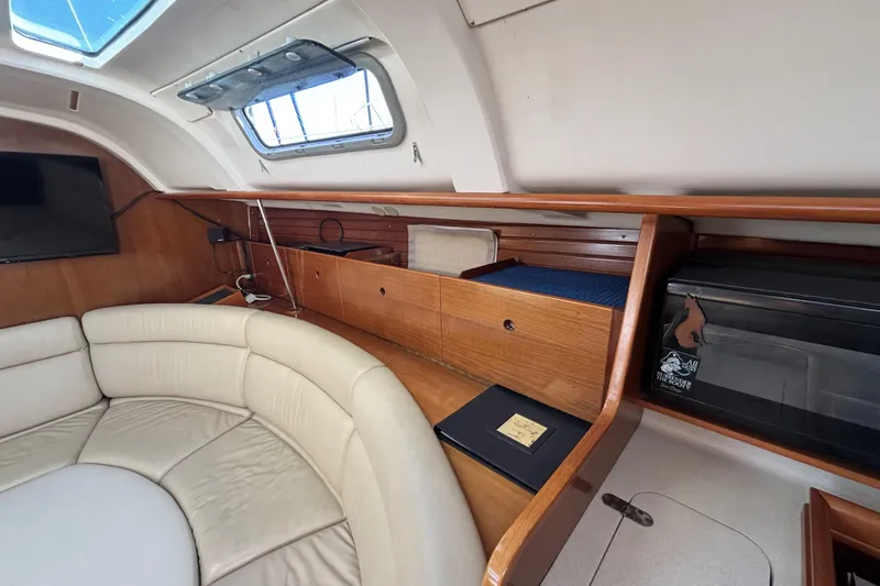 Interior of 1997 Beneteau Oceanis 400 yacht with leather seating and wooden cabinetry.