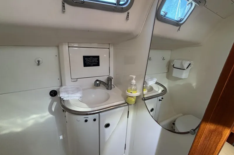 Bathroom interior of 1997 Beneteau Oceanis 400 yacht, featuring sink and mirror.