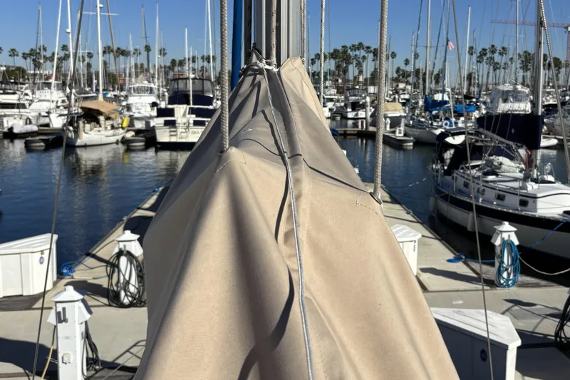 Beneteau Oceanis 400 sailboat docked at marina, surrounded by other boats, sunny day.