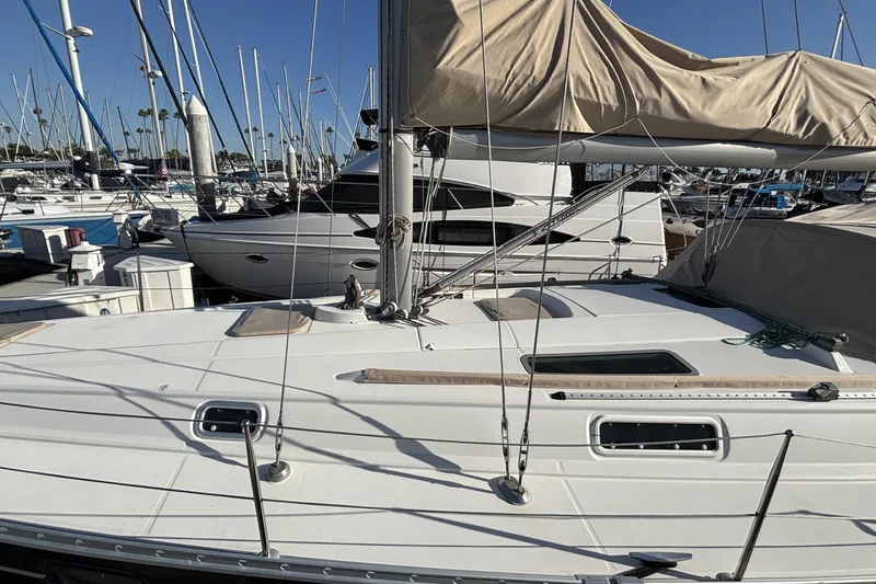 1997 Beneteau Oceanis 400 sailboat docked in a marina under clear blue skies.