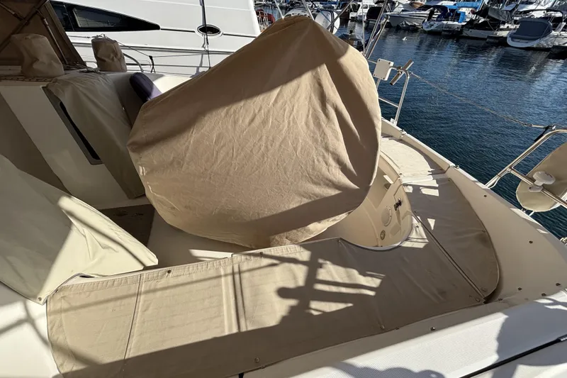 1997 Beneteau Oceanis 400 sailboat deck with beige covers, docked at marina.