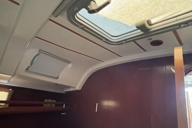 Interior cabin view of a 1997 Beneteau Oceanis 400 sailboat, featuring a skylight and wooden paneling.