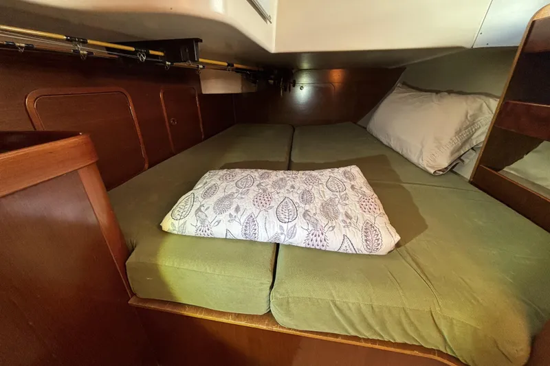 Cozy cabin interior of 1997 Beneteau Oceanis 400 sailboat with green bedding.