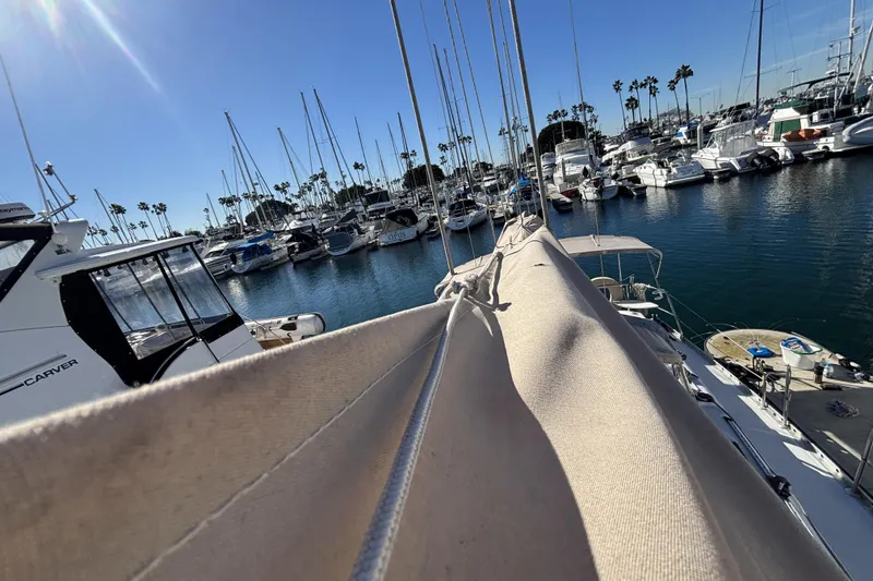 Beneteau Oceanis 400 sailboat docked in a sunny marina, surrounded by other boats.